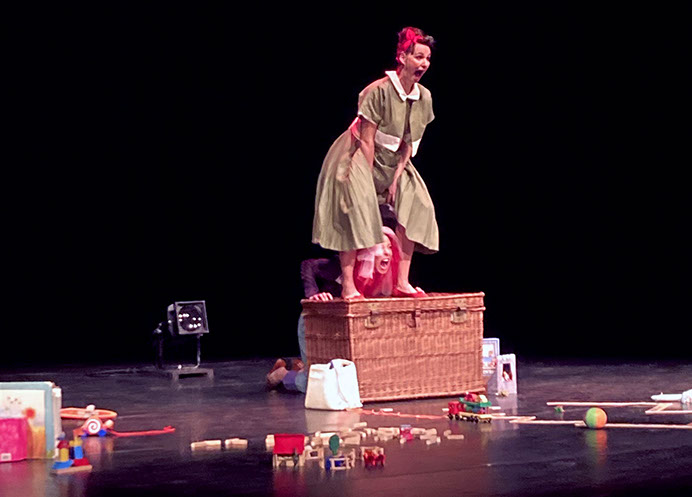 Photo spectacle: deux femmes sur scène, l'une en robe verte, l'autre déguisée en lion.