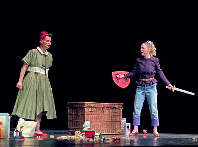 Photo spectacle: deux femmes sur scène, l'une en robe verte, l'autre déguisée en lion.